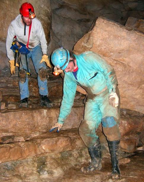 Photo of two cavers descending a wide stone staircase