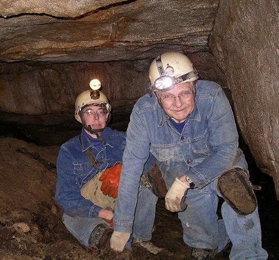 Photo of two cavers in a cave room