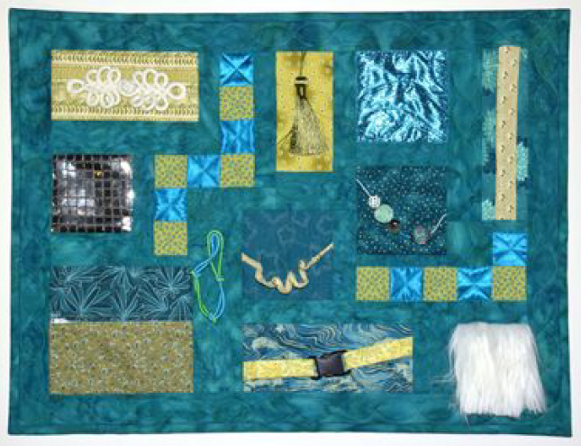A blue quilt with multiple fabrics and textures.