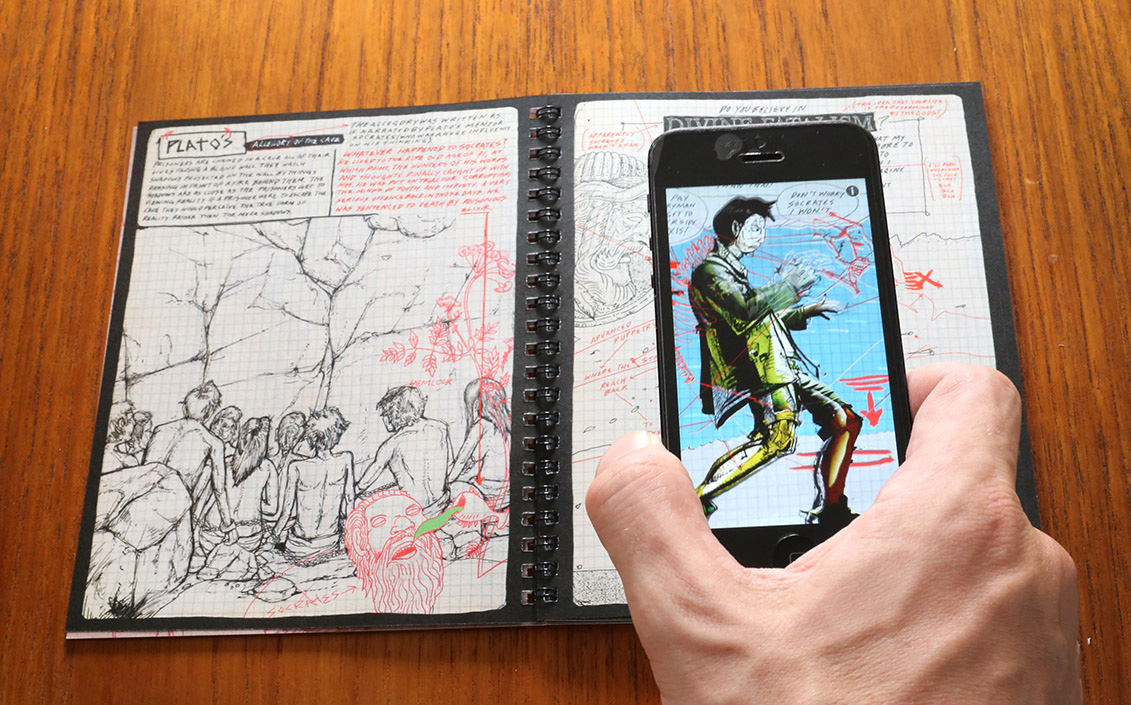a photo depicting the reading experience of .
                  The comic is laid open on a table, and the reader's hand is visible holding a
                  phone above one of the pages. On the phone screen, we see an altered version of
                  the comic page, featuring more color.